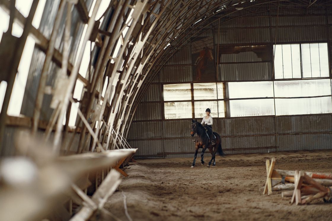 Rider on a horse inside a wooden indoor riding arena